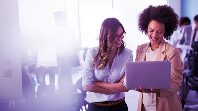 Colleagues collaborating on a laptop in a modern office