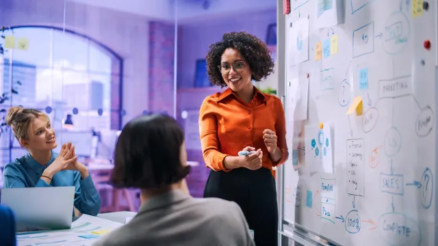 Image of woman leading a presentation to her team
