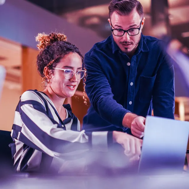 Image of two officemates discussing in a workstation