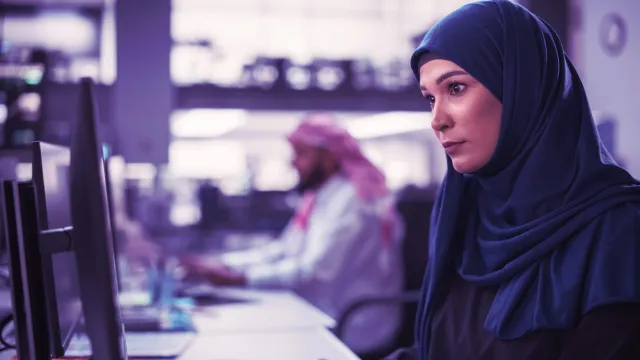 Image of Muslim woman looking at computer screen