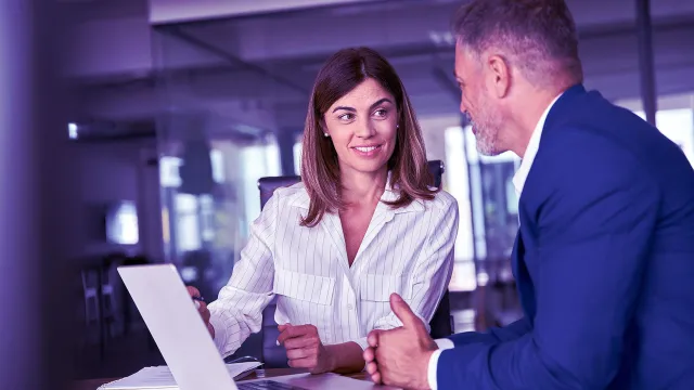 Image of officemates discussing in front of a laptop