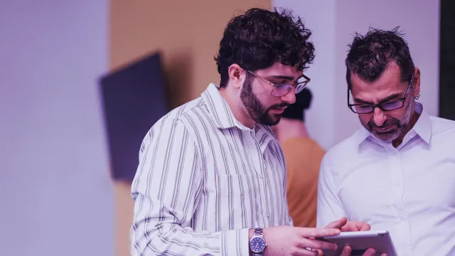 Colleagues reviewing information together on a digital tablet