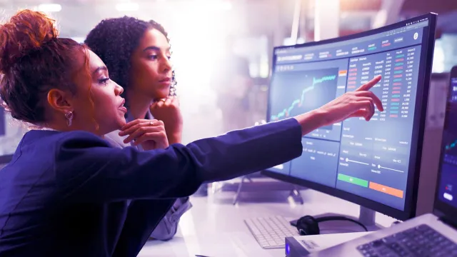 Image of two women reviewing stats in monitor