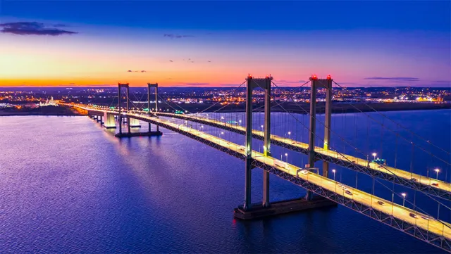 Aerial view of Delaware Memorial Bridge at dusk. The Delaware Memorial Bridge is a set of twin suspension bridges crossing the Delaware River between the states of Delaware and New Jersey