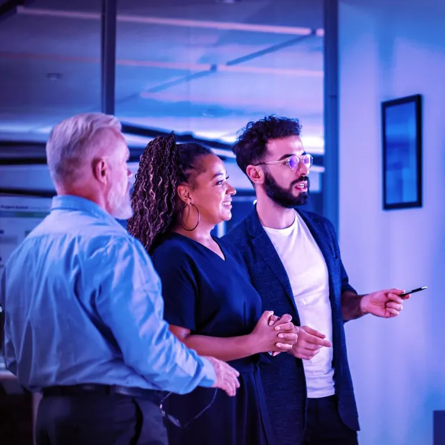 Image of three officemates looking at a presentation