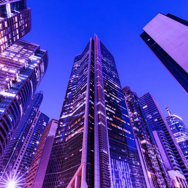 Image of worm's eye view of tall buildings at dusk