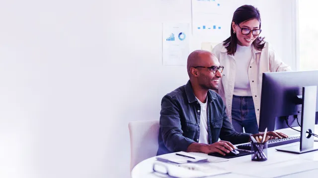 Team collaboration around desktop computer in a modern office