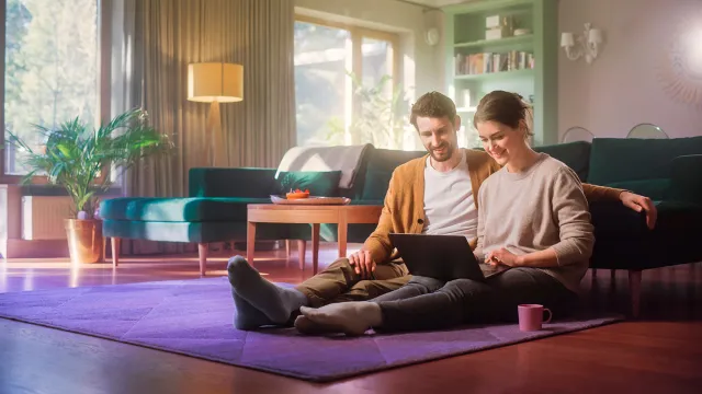 Image of happy couple working on a laptop at home
