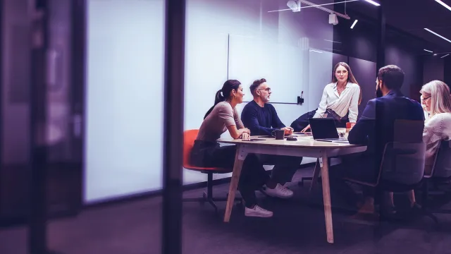 Image of team discussing inside a meeting room