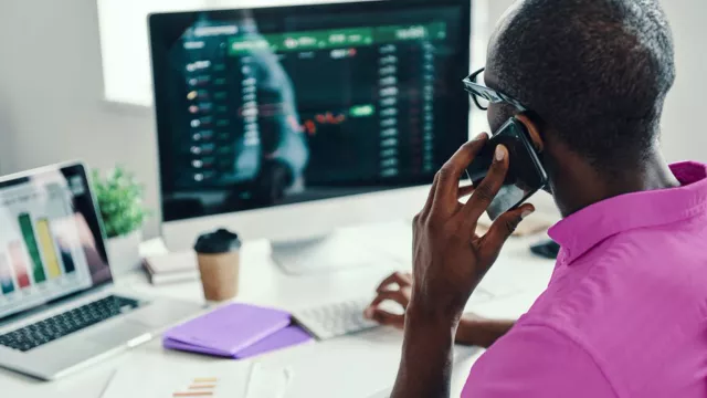 Man on phone in front of computer