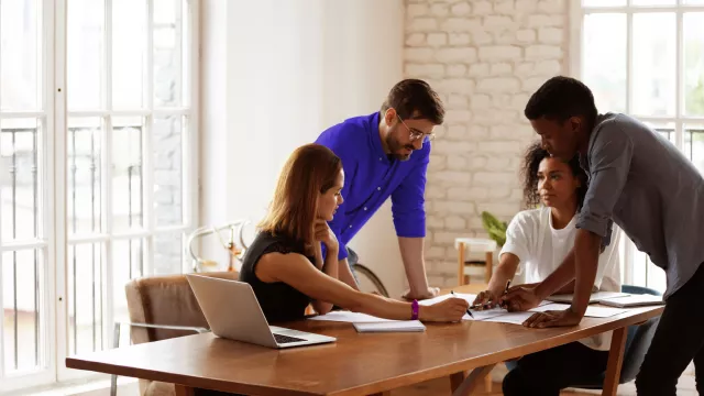 Team of 4 collaborating in office