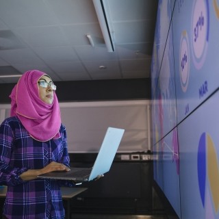 Woman looking at data on tv wall