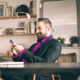 man looking at phone in office
