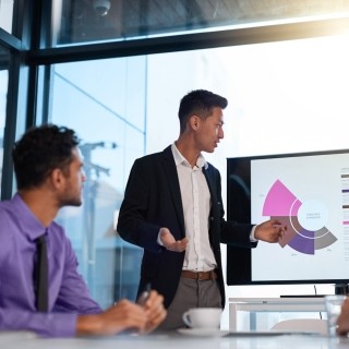 man gives a presentation with graphs on chart