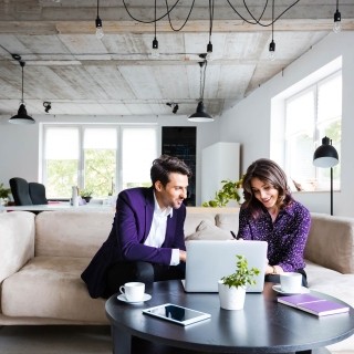 Image of a man and a woman having a discussion in front of laptop