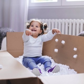Image of little girl playing in box full of foam