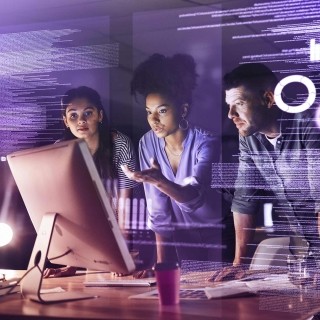 Image of team discussing in front of a computer