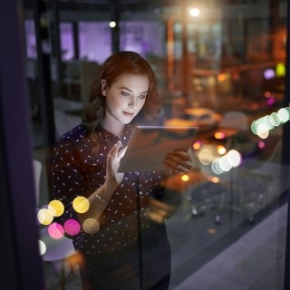 Image of girl holding laptop and standing near window