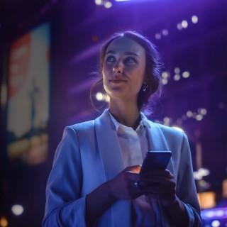 Image of woman holding phone out at night