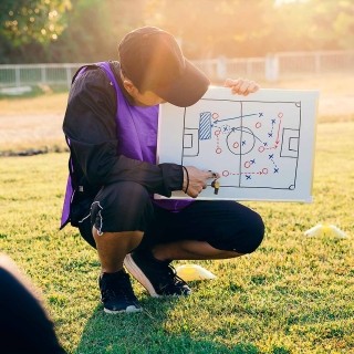 Image of sports coach explaining gameplay in white board