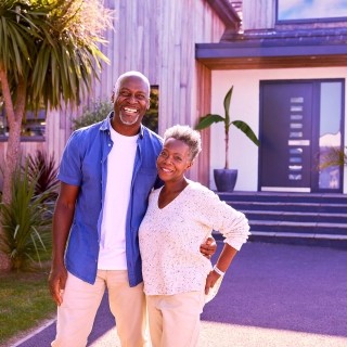 Image of happy couple in front of house