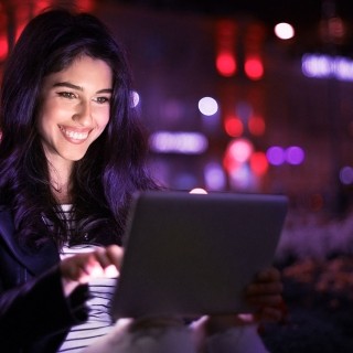 Image of woman working on tablet at night