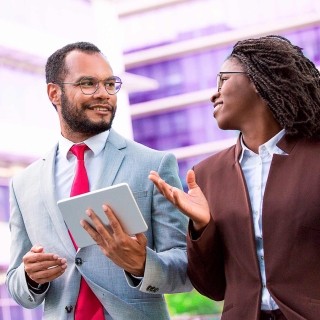 Image of man and woman discussing work outdoors
