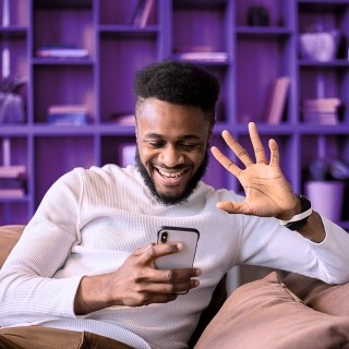 Image of man in a phone call smiling and waving