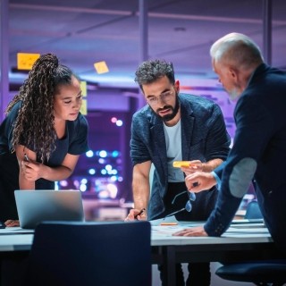 Image of officemates discussing around a table