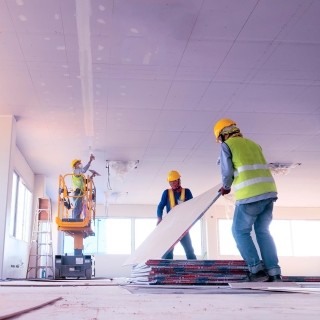 Image of construction workers working in an empty floor