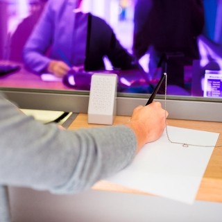 Image of arm and hand signing document