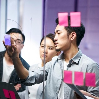 Creative team brainstorming with sticky notes in a collaborative office setting.