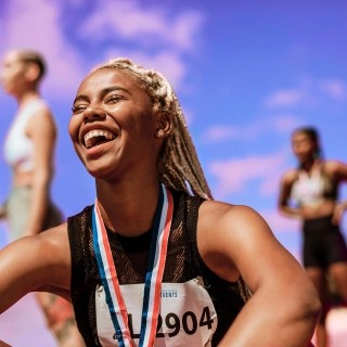 Image of athlete wearing a medal, smiling