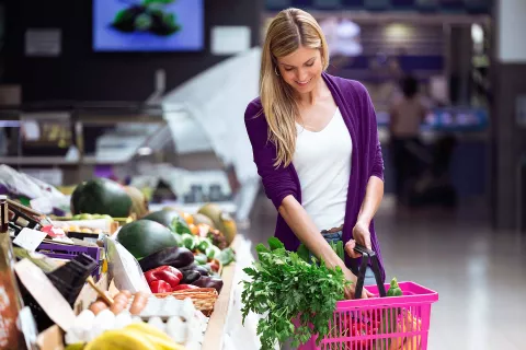 Woman with basket full of vegetables in market
