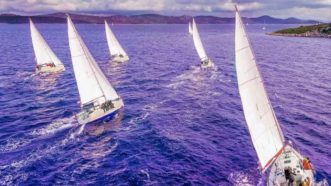five boats at sea in cloudy weather