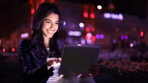 Image of woman working on tablet at night