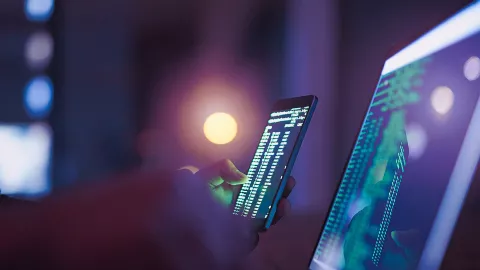 Image of a mobile phone and a laptop with charts