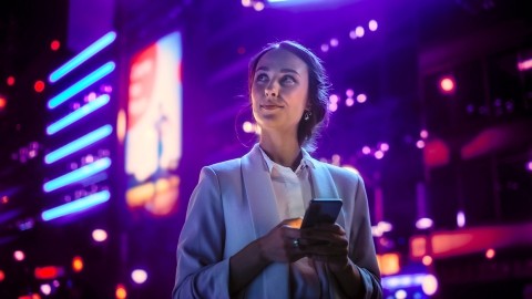 Image of woman holding phone out at night