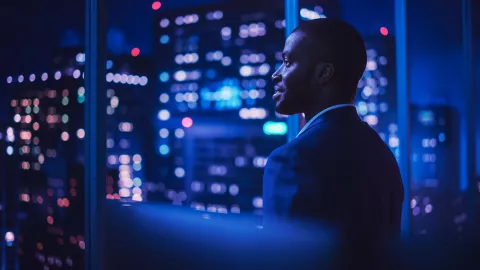 Image of a man looking out of a building window
