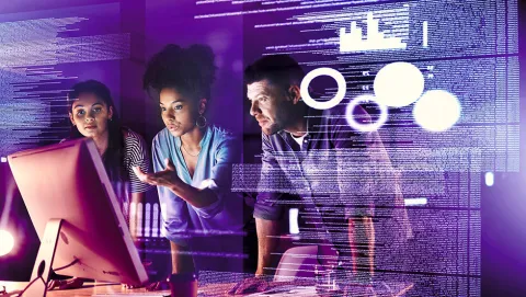 Team collaborating on a computer with data visualization and code overlay.
