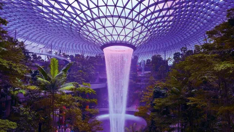 Rain Vortex at Jewel Changi Airport, Singapore, world's tallest indoor waterfall under a glowing glass dome.