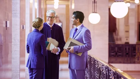 Image of three people discussing in a hallway