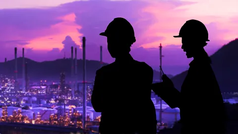 Image of two persons wearing hard hats with cityscape in the background