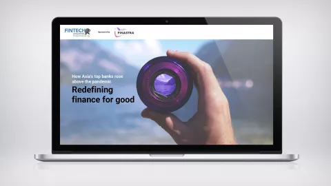 Image of laptop with hand holding camera lens