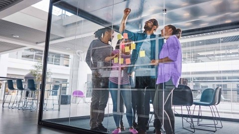 Image of team collaborating in glass office