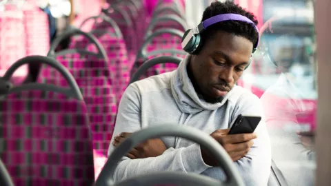 Image of man with headphones looking at phone